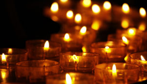 A sea of small tealights on a dark background.