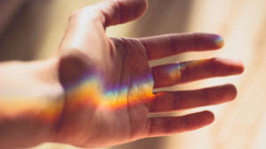 A rainbow spectrum appearing on the palm of a hand. 