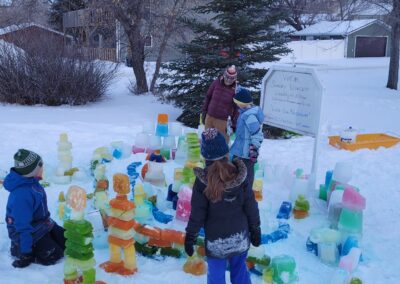 Kids and colourful ice blocks on snow.