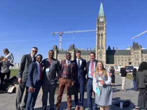 A group of people standing in front of the Peace Tower, Ottawa. 