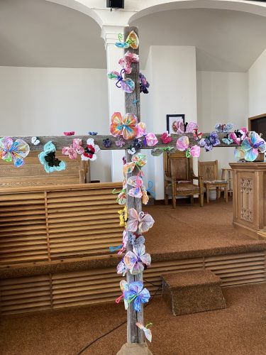 A cross decorated with butterfly crafts